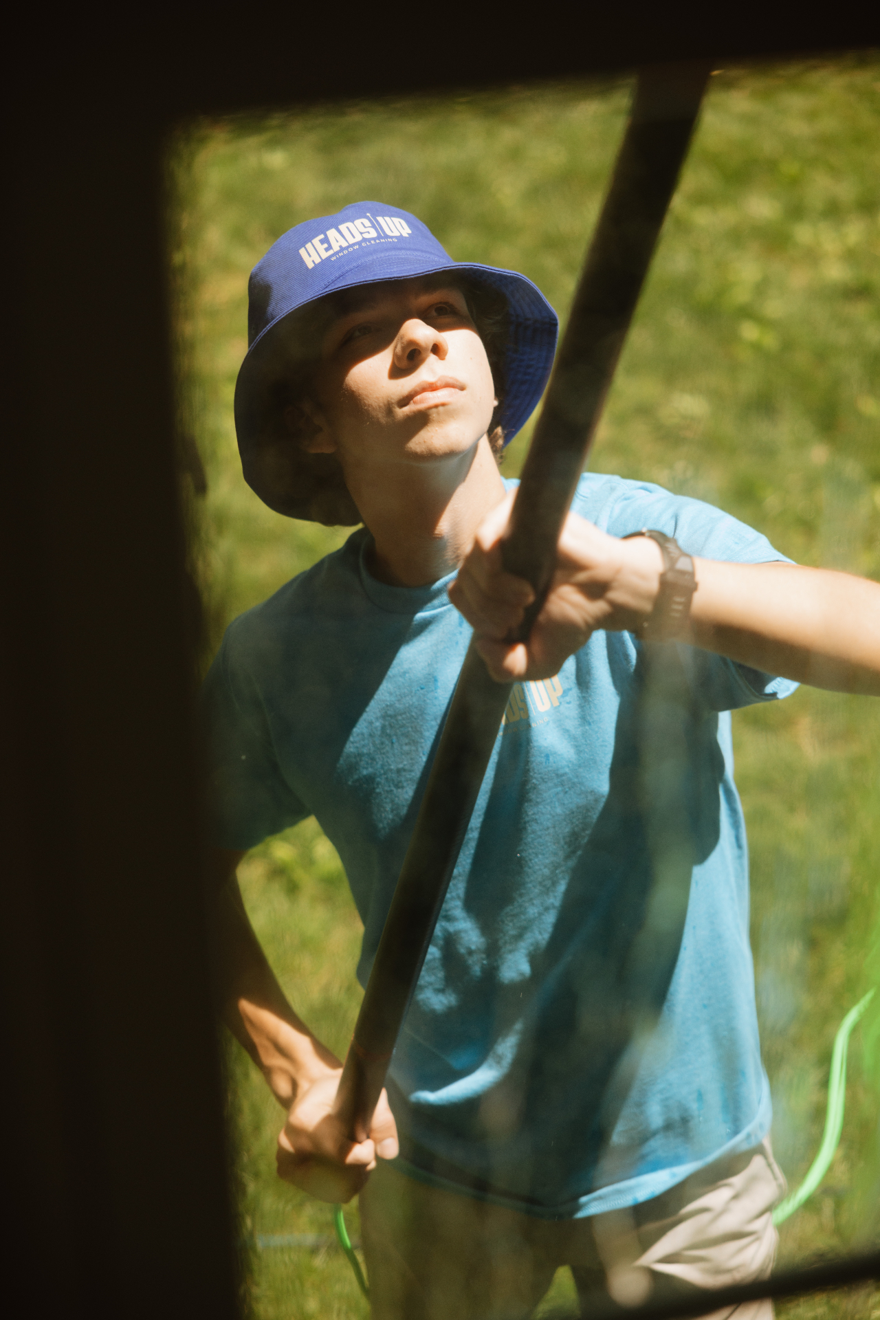 Close-up of a Heads Up team member cleaning a window
