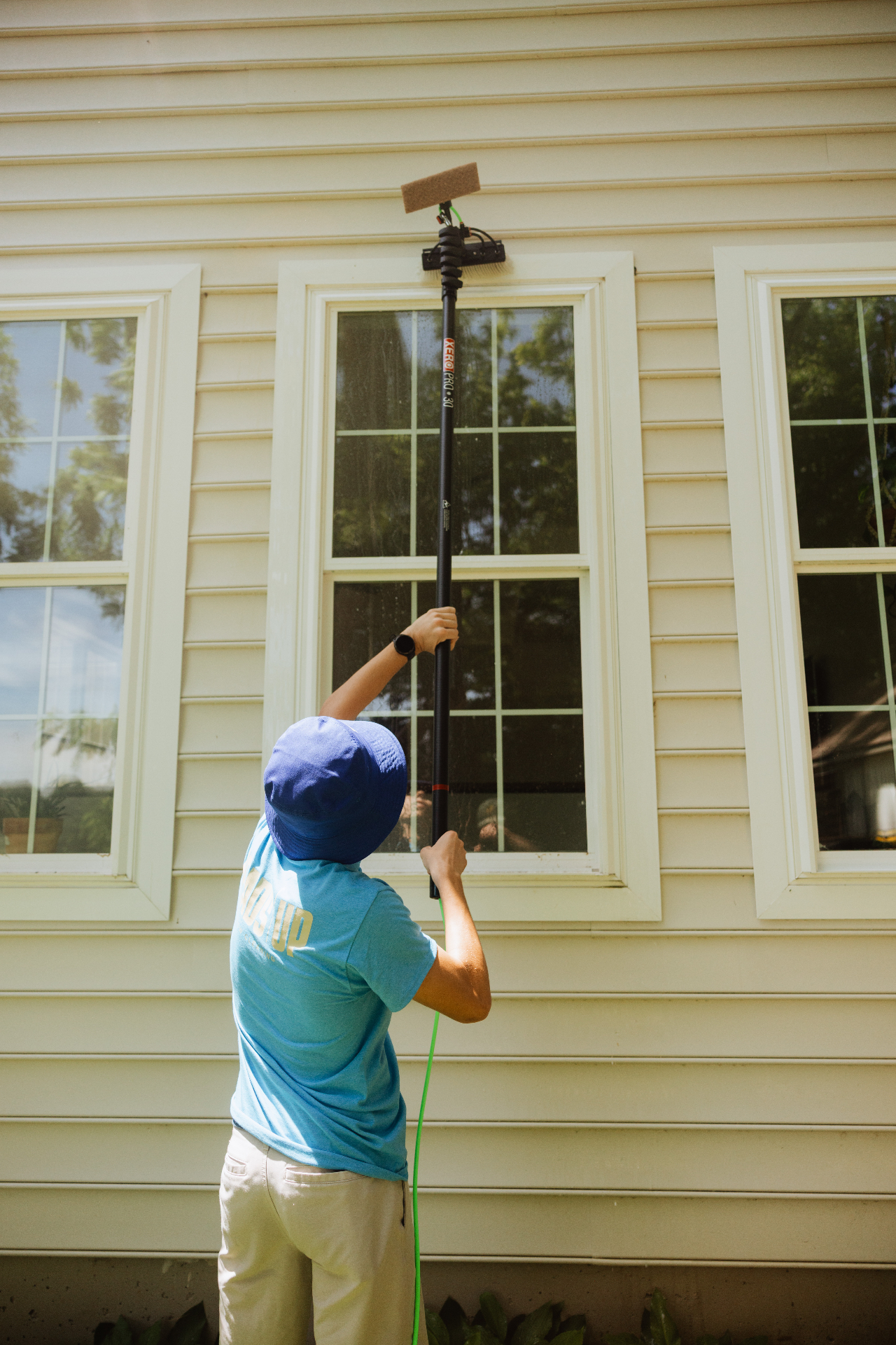 Heads Up technician reaching high windows with a water-fed pole